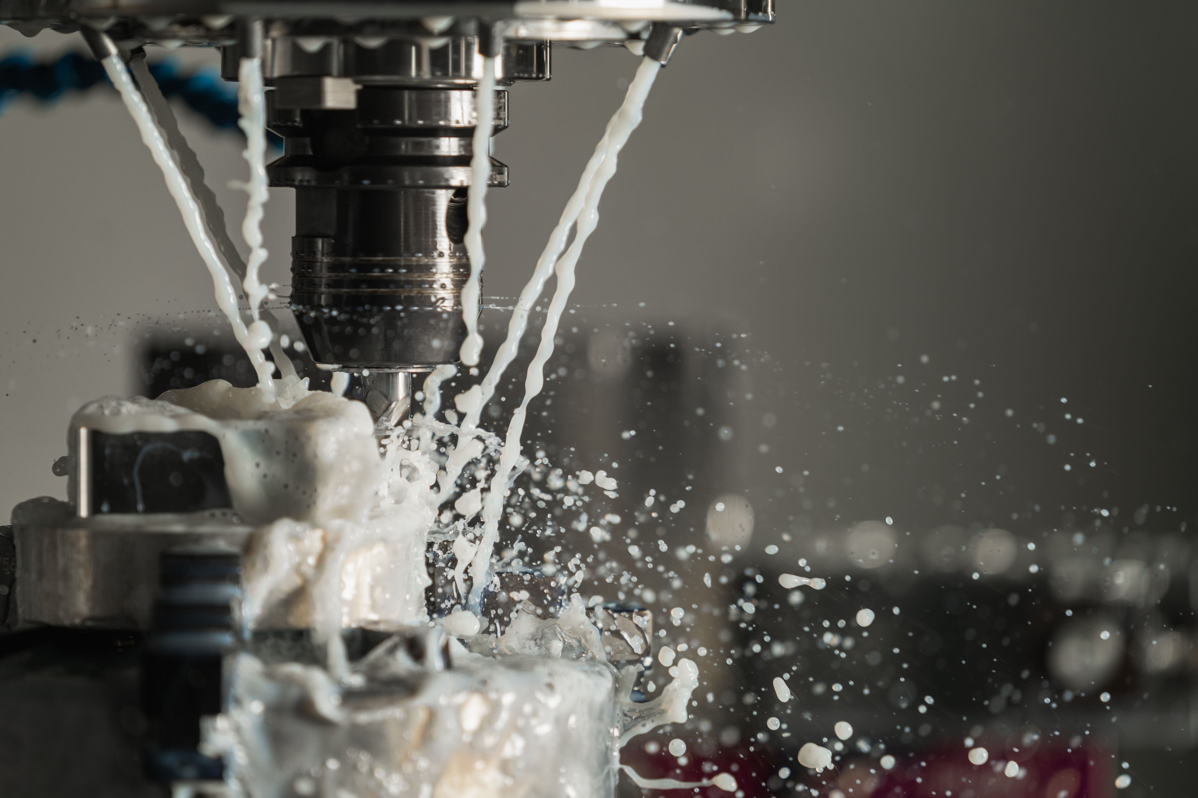 Close-up of a CNC machine with coolant splashing during precision metalwork